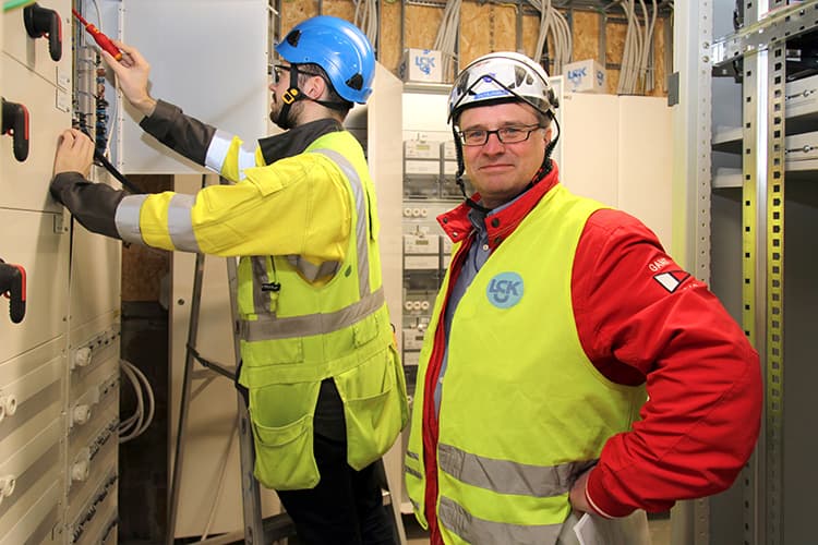 <p data-block-key="sfnoy">LSK:n Mika Petäjämaan mukaan uusia sähköpääkeskuksia on joskus vaikea saada mahtumaan kellaritiloihin, sillä ennen vanhaan sähkökeskukset olivat selvästi nykyistä pienempiä. Vieressä sähköinsinööriksi opiskeleva sähköasentaja Robert Ellmen.</p>