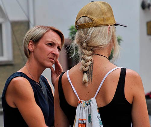 naiset keskustelevat taloyhtiön pihalla