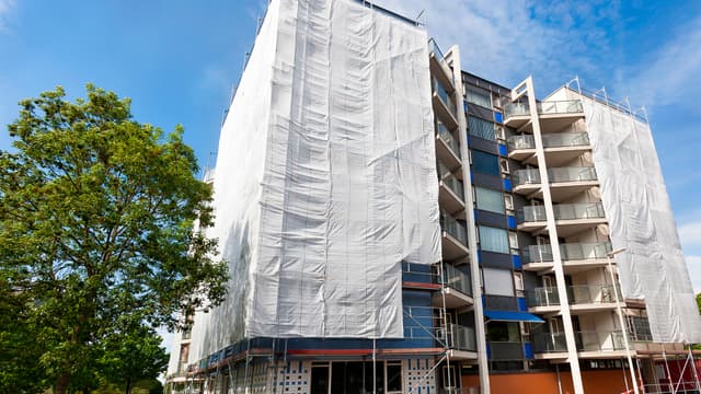 Huputettu kerrostalo jonka ympärillä on rakennustelineet