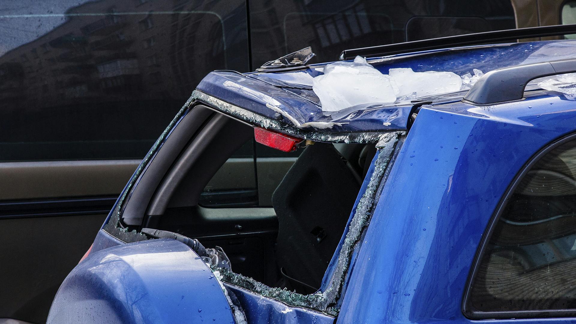 sinisen auton katolle pudonnut jääpala on hajottanut takaikkunan ja katto on lommolla