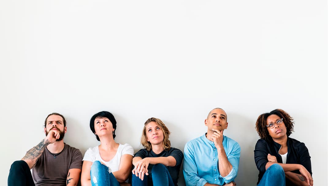 ihmiset istuvat lattialla rivissä ja katsovat ylöspäin ja ihmettelevät