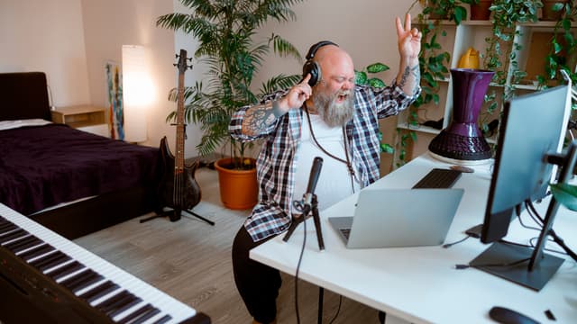 mies laulaa musiikin tahtiin kuulokkeet korvilla